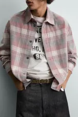 Camisa de corte relajado confeccionada en pana de algodón con diseño de cuadros. Presenta cuello solapa, cierre frontal de botones y mangas largas con puños abotonados.