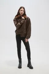 Campera de eco-cuero color marrón con cuello de piel sintética, cierre frontal, bolsillos frontales con solapa y puños y cintura elásticos.
