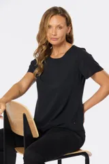 Blusa blanca con estampado floral negro, de corte recto y manga corta.