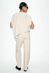 Pantalón de tiro medio confeccionado en tejido de punto elástico con pierna recta. Cuenta con cintura elástica ajustable mediante cordones y bolsillos laterales.