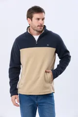 Buzo polar bicolor de hombre, con diseño en negro en la parte superior y gris en la inferior. Cuenta con cuello alto, cierre frontal medio y bolsillos laterales con cierre.