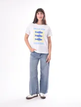 Remera color crudo de corte recto y mangas cortas, con estampado de un pez koi rojo en el pecho. 