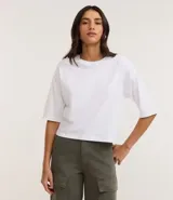 Remera básica blanca de algodón, corte cropped y manga corta ancha, con cuello redondo.
