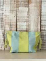Bandolera tipo sobre de cuero con diseño en bloques de color verde lima y celeste, decorada con borlas colgantes en los laterales.
