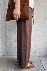 Pantalón de corte babucha color chocolate, de diseño holgado con cintura elástica fruncida y cordón ajustable.