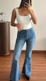 Jean de denim azul de tiro medio, corte semi oxford con botamanga deshilachada.