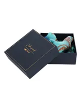 Pañuelo cuadrado de seda, color celeste/turquesa, con estampado temático marino en tonos naranjas y azules, anudado al cuello.