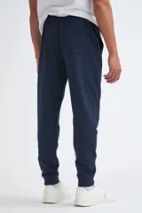Pantalón tipo jogger de corte deportivo, color azul marino, con cintura elástica y puños acanalados en los tobillos.