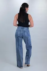 Pantalón jean wide leg de tiro alto en color azul, con diseño de costuras diagonales contrastantes en el frente y corte amplio en las piernas.