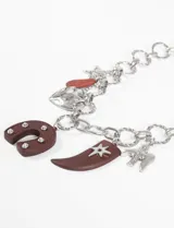 Collar con cadena gruesa dorada y dijes colgantes de corazón, estrella, herradura y cuerno.