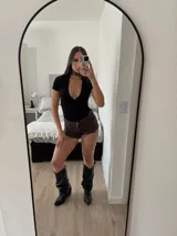 Short de jean negro con ruedo desflecado y detalle de tachas metálicas en forma de estrella en los bolsillos delanteros.