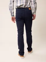 Jean de corte recto y tiro medio en color azul marino, con cierre de botón y cremallera, y bolsillos laterales y traseros.