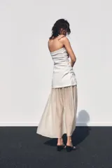Vestido midi de escote palabra de honor con cuerpo drapeado y falda de tejido combinado con caída fluida. Presenta cierre con cremallera oculta.
