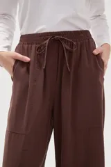 Pantalon de viscosa color verde militar, de corte ancho y tiro medio, con cintura elástica y cordón ajustable.