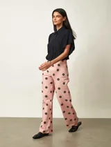 Pantalon tipo jean de corte recto, color rosado con estampa de lunares negros.