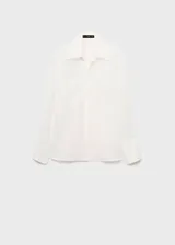Camisa de corte recto y diseño clásico con cuello camisero, manga larga con puños abotonados y cierre frontal de botones ocultos. Presenta parches decorativos sutiles en la parte frontal.