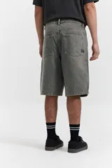 Bermuda de jean con calce baggy, de tiro medio y corte amplio en piernas y cadera. Presenta un lavado desgastado en tono grisáceo, con pasacintos y bolsillos laterales y traseros.