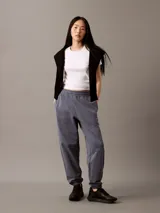 Pantalón de jogging gris de felpa con cintura elástica ajustable con cordón, bolsillos laterales, bajos de canalé y logo CK bordado en la pierna.