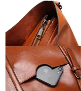 Bolso tipo tote de eco cuero color marrón, con doble asa de hombro, bolsillo externo y cierre superior.