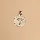 Dije circular de plata 925 con relieve del símbolo del caduceo de la medicina en el centro y borde texturizado.