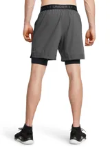 Short deportivo 2 en 1 Under Armour, compuesto por un short exterior gris de tejido ultraligero y un short interior de compresión negro. Cuenta con paneles perforados para ventilación, bolsillos laterales y cintura con cordón ajustable.