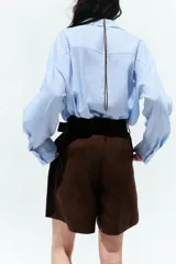 Bermuda de tiro alto color azul marino, con pinzas delanteras, bolsillos laterales y cinturón trenzado color marrón.