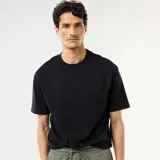 Remera negra de corte oversize y cuello redondo, confeccionada en algodón.