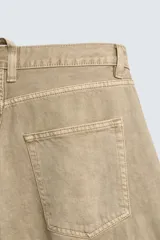 Bermuda de corte relajado en denim de algodón color beige, estilo cargo, con cinco bolsillos y bolsillos plastrón con solapa en las perneras.