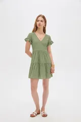 Vestido corto de viscosa color verde, con escote en V, mangas cortas con volados y diseño escalonado en la falda.