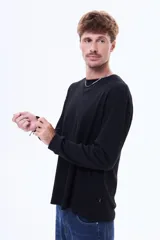 Buzo de manga larga con textura tipo waffle, cuello redondo y corte holgado.