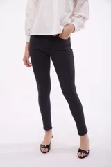 Jean skinny de tiro medio, color azul medio, con bolsillos delanteros y traseros.