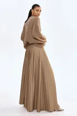 Buzo de punto marrón, con textura suave y peluda, escote redondo y hombros caídos. Presenta remates acanalados en cuello, puños y bajo.