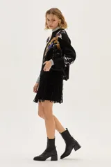 Bota tipo chelsea de cuero charolado color bordó, con caña media, elásticos laterales negros y taco cuadrado bajo.