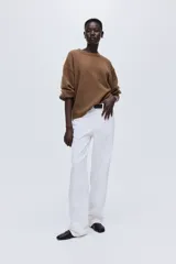 Buzo de punto color marrón, de manga larga con cuello redondo, hombros caídos y puños y bajo acanalados.