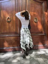 Remera blanca de encaje con diseño cruzado tipo wrap, mangas largas con terminación acampanada y detalle de bordado floral a tono. Presenta un ajuste al cuerpo con lazo lateral y borde con terminación delicada en el escote.