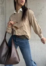 Sweater de punto color beige con diseño bordado en relieve de flores y hojas. Presenta cuello redondo, mangas largas con puños acanalados y un corte holgado.