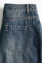 Jean de cinco bolsillos en denim de algodón, de cintura estándar, diseño curvo y corte holgado con efecto desgastado.