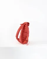 Mochila acolchada color beige con cierre superior enrollable y hebilla.