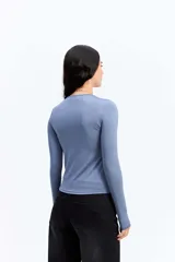 Remera de manga larga ajustada al cuerpo, confeccionada en tejido elástico de poliéster y spándex, con cuello redondo clásico.