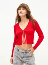 Saco rojo de tejido de punto con escote en V y lazo de ajuste en el frente.