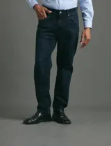 Pantalon denim de cinco bolsillos, corte recto y color negro, con botones y remaches metálicos en tono plata viejo.