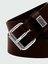 Cinturón de cuero marrón oscuro con hebilla metálica plateada de doble argolla y textura rugosa. Incluye un pasante de cuero con placa metálica grabada con el logo de Diesel.