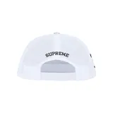 Gorra tipo trucker con panel frontal estampado con diseño de camuflaje de ramas y hojas, y parte trasera de malla blanca. Presenta un parche bordado en el frente con el logo de Supreme y una figura femenina, además del logo de TrueTimber Camo bordado en el lateral.