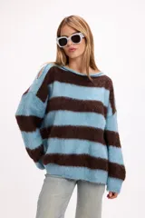 Sweater de punto con diseño de rayas horizontales anchas en color celeste y marrón, de corte holgado, cuello redondo y detalle de aberturas en los hombros.