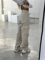 Pantalón cargo color beige, de corte recto y tiro alto, con bolsillos laterales con solapa y bolsillos delanteros.