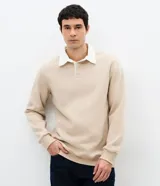 Buzo masculino de algodón con felpa, color beige, con cuello polo blanco contrastante, manga larga y puños acanalados.