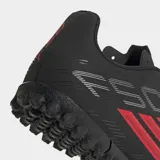Championes de fútbol Adidas F50 Club para césped artificial, color negro con detalles en rojo y blanco. Presentan un exterior sintético liviano, lengüeta transpirable y suela de caucho con tapones diseñados para un agarre óptimo en canchas artificiales.