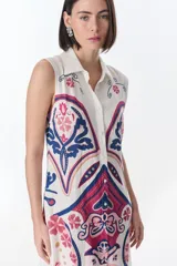 Vestido largo color crema con estampado cachemir en tonos marrones, con cuello camisero, sin mangas y abotonado al frente.