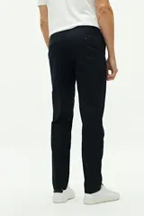 Pantalón chino de corte regular, confeccionado en tejido de algodón con elastano. Presenta cierre frontal con botón y cremallera, bolsillos laterales y traseros, y trabillas para cinturón.