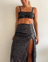 Pollera larga negra cubierta de lentejuelas, con tajo lateral alto.